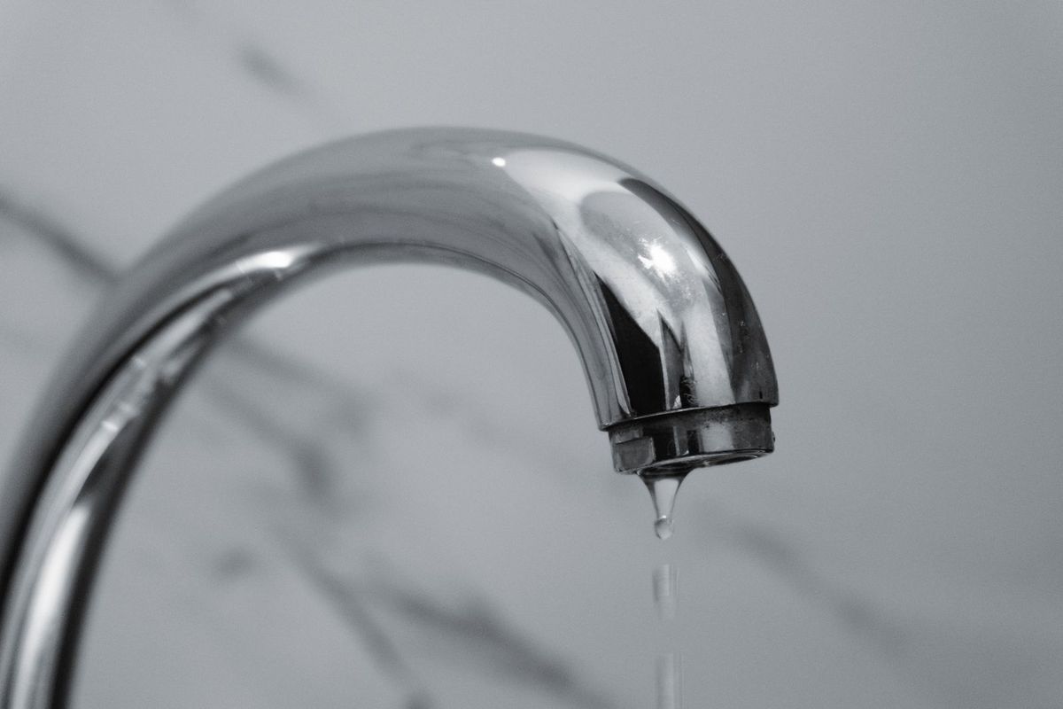 Water dripping from a chrome bathroom faucet