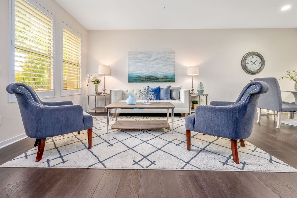 Living room with a large patterned area rug under a coffee table and two armchairs