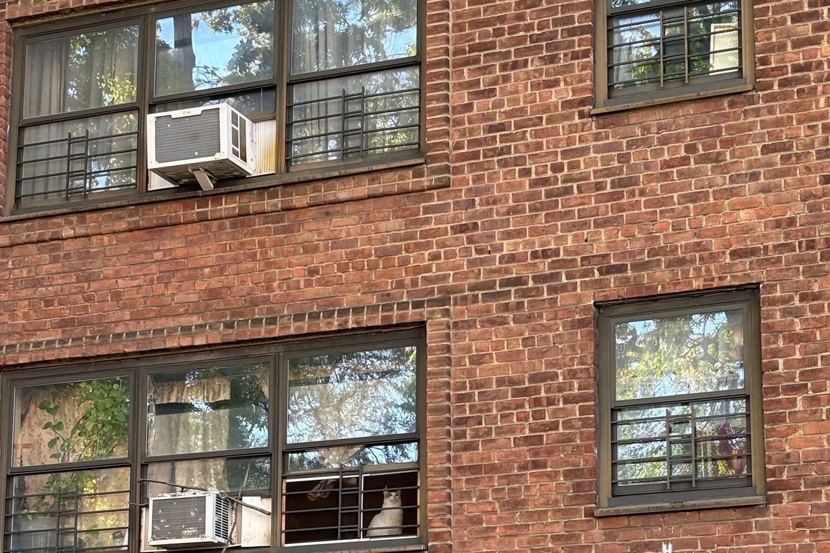 Window air conditioners in the windows of a brick apartment building